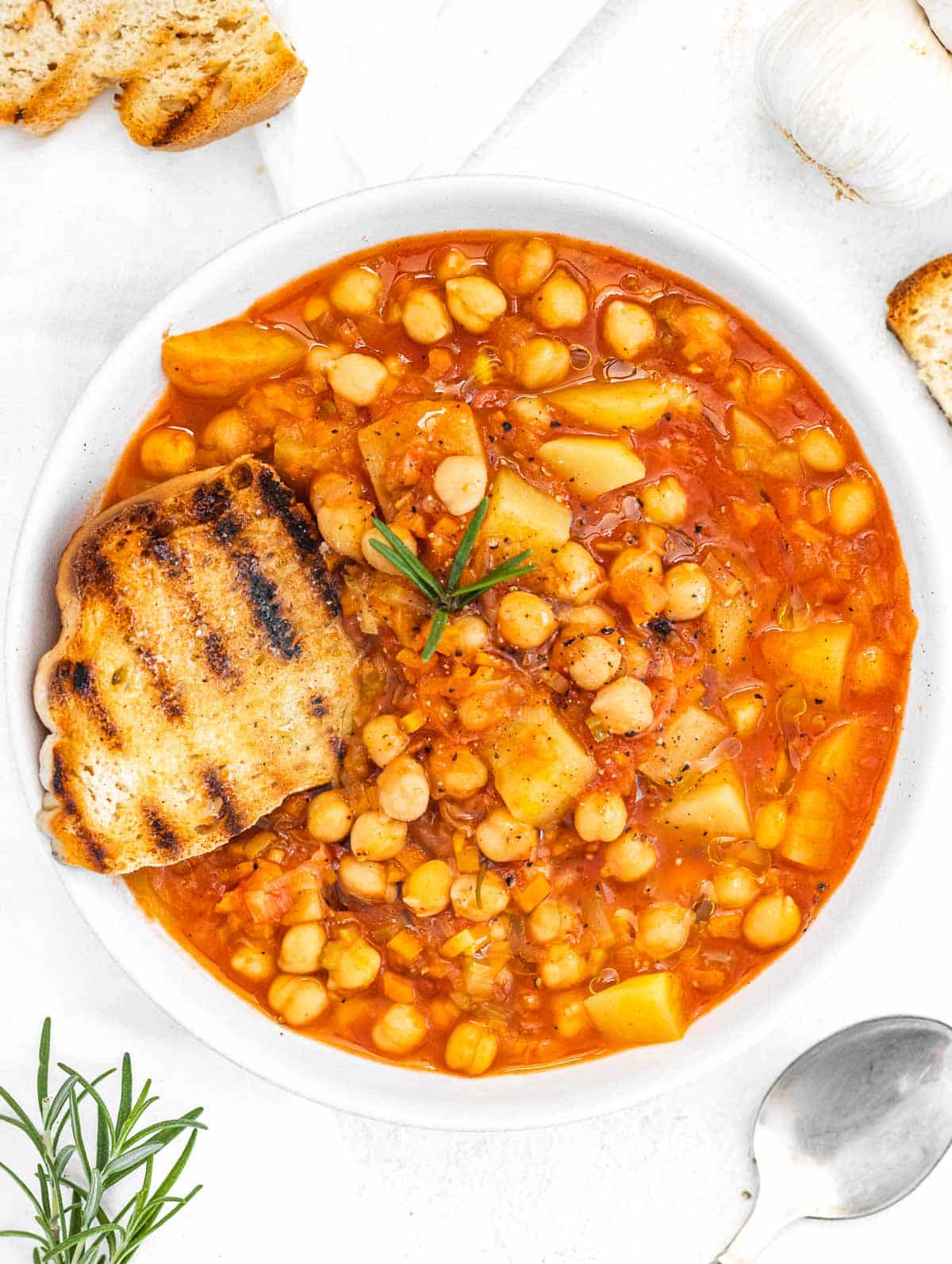 Chickpea soup in a white bowl with bread