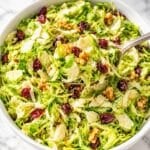 Shaved Brussels Sprouts Salad piled with cranberries and chopped walnuts.