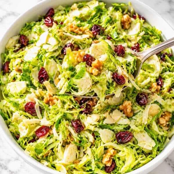 Shaved Brussels Sprouts Salad piled with cranberries and chopped walnuts.
