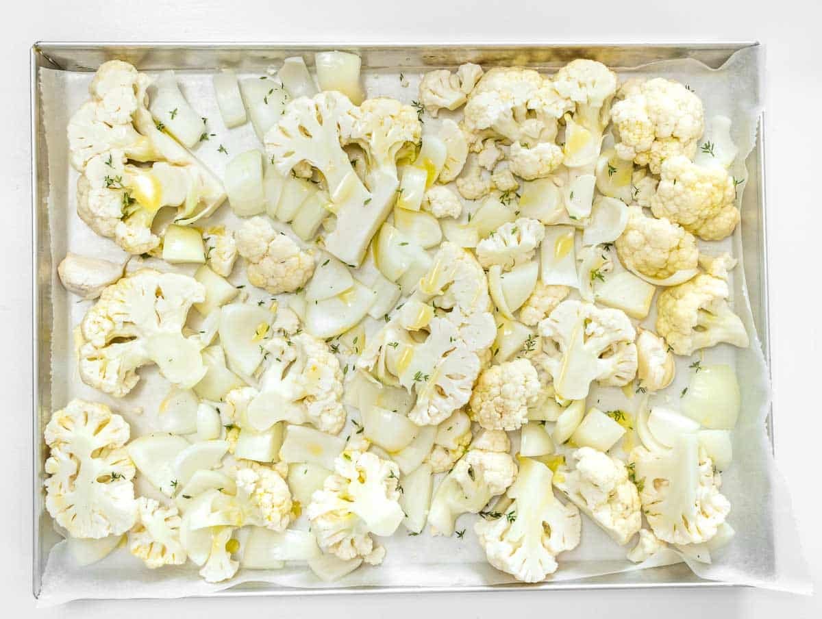 cauliflower, onion, and garlic on a baking tray