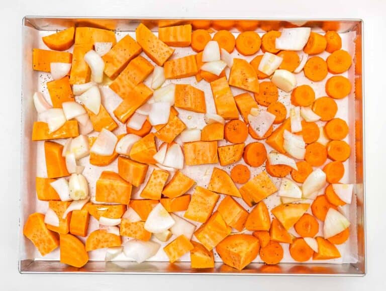 sweet potato and carrots on a baking sheet