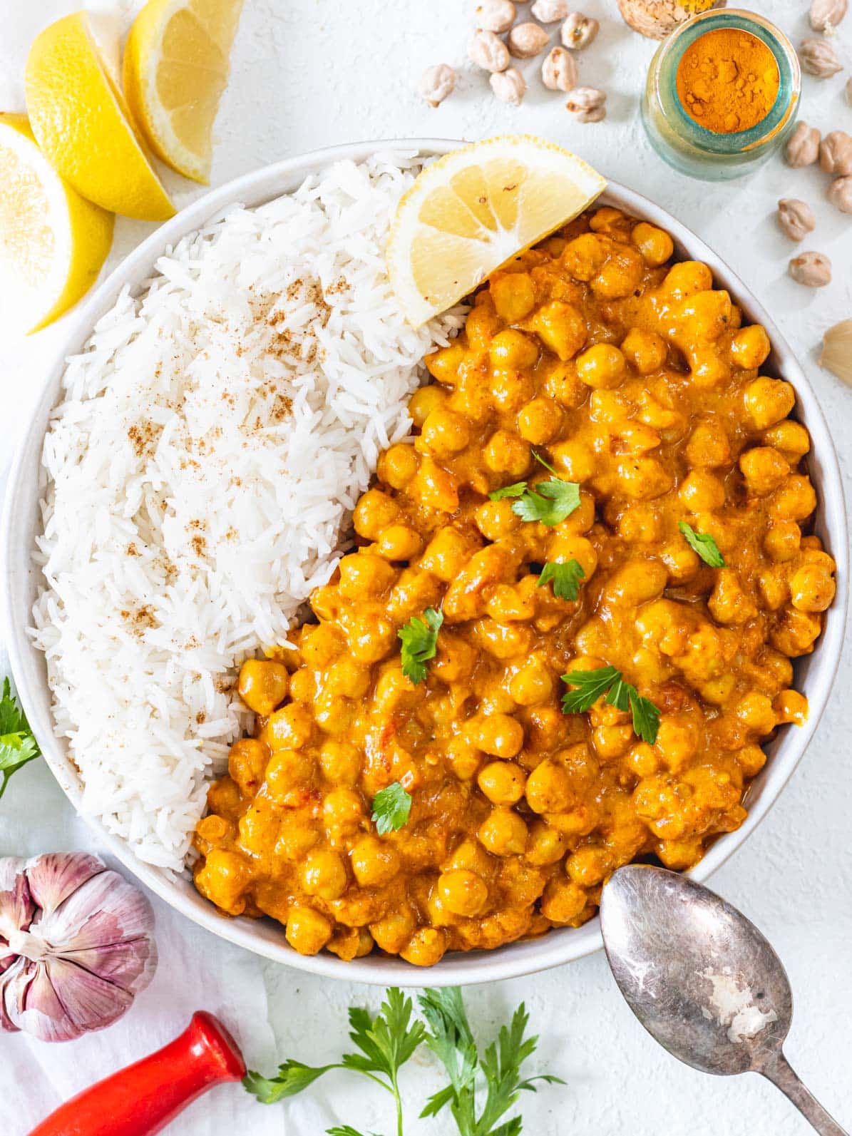 Chickpea Curry in a bowl with white rice and lemon