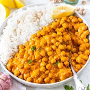 chickpea curry with silver spoon and white rice