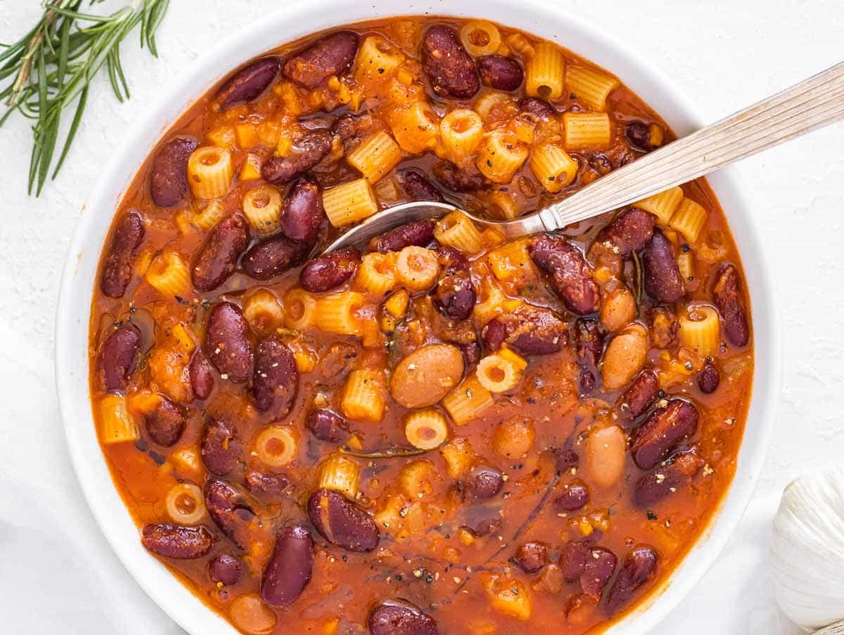 pasta fagioli in a white bowl with spoon