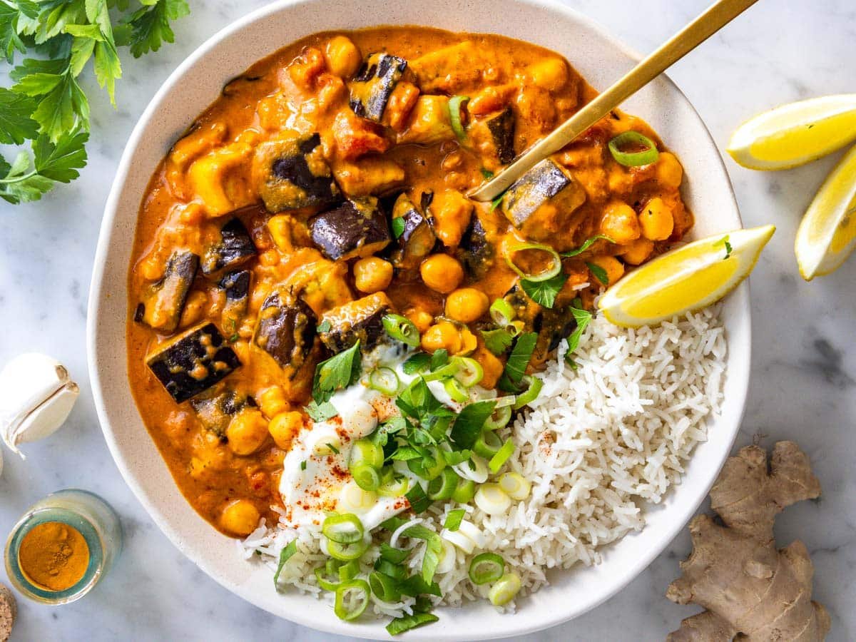 Eggplant curry with basmati rice and lemon wedges.