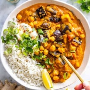 Eggplant curry with basmati rice, yogurt, and a spoon.