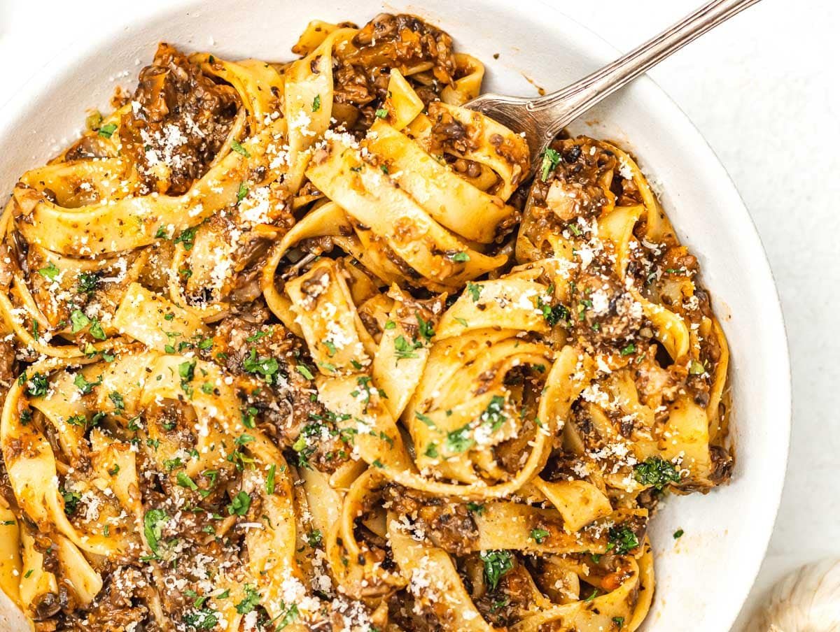 Mushroom Bolognese with vegan parmesan and a fork