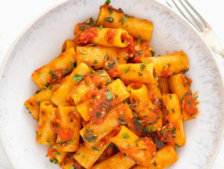 rigatoni arrabbiata in a plate with fresh parsley on top