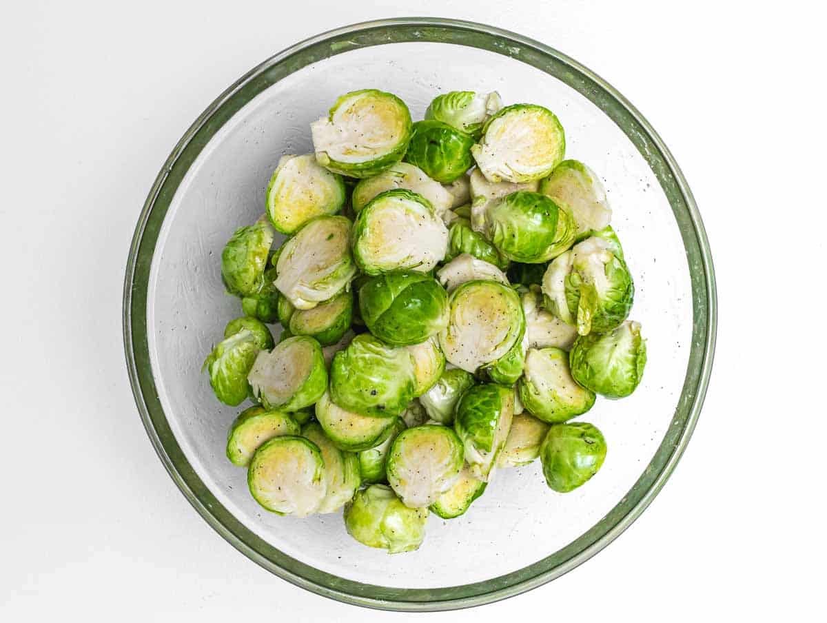 Brussels sprouts and oil in bowl