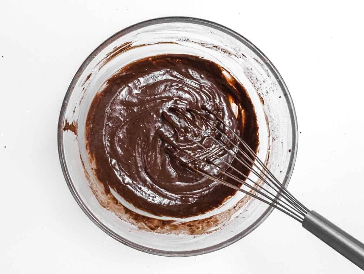 Whisk and chocolate mix in a glass bowl