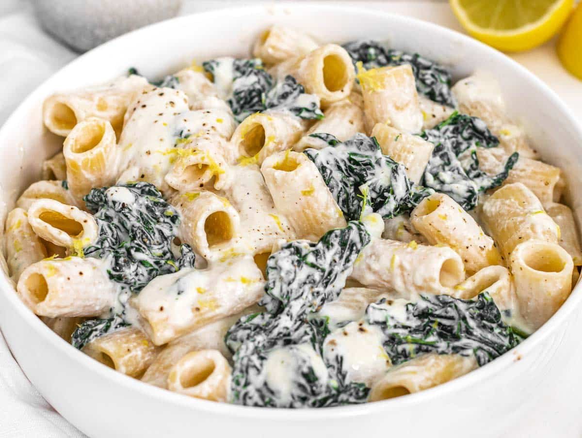 Creamy Kale Pasta in a white bowl with lemon