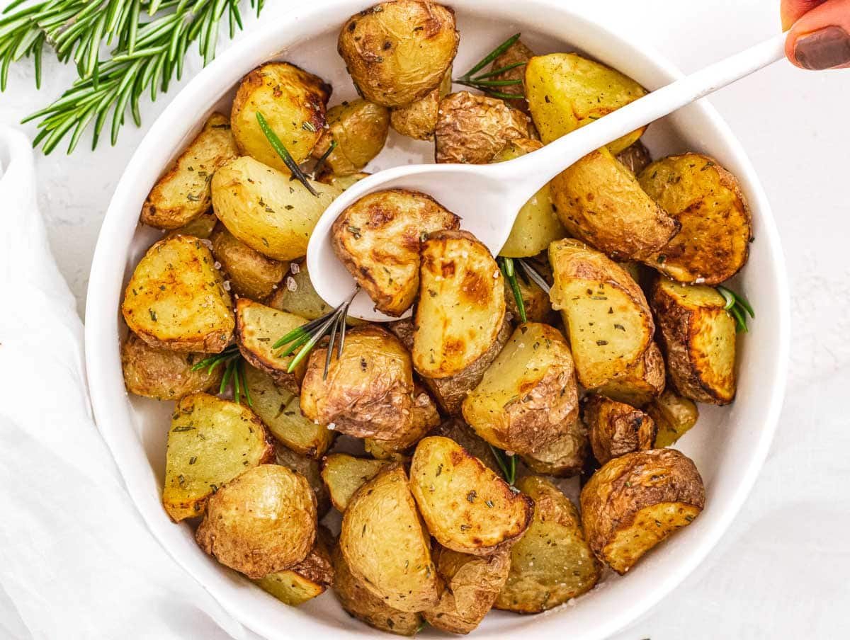 Air fryer potatoes with hand and spoon