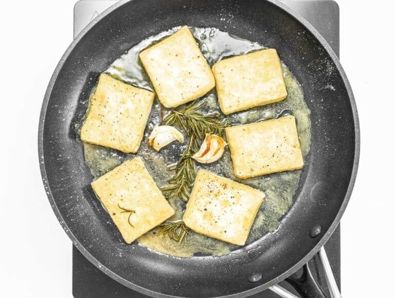 pan frying the tofu with oil on a pan