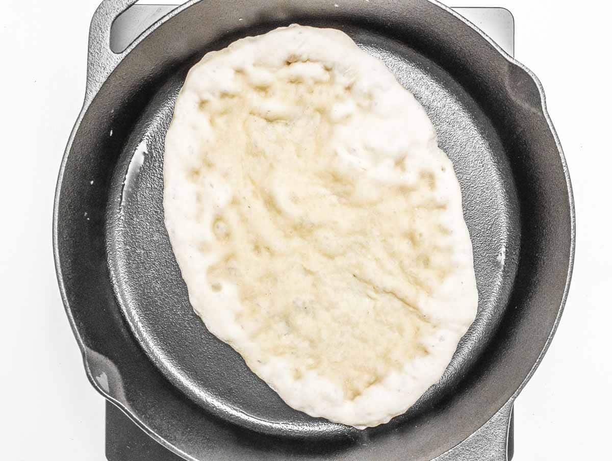 Naan bread cooking in a pan