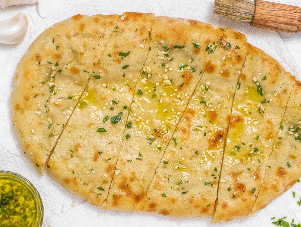 Naan bread cooked on a pizza stone brushed with oil