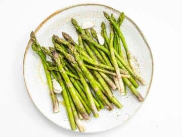 tossing asparagus in oil, salt, and pepper
