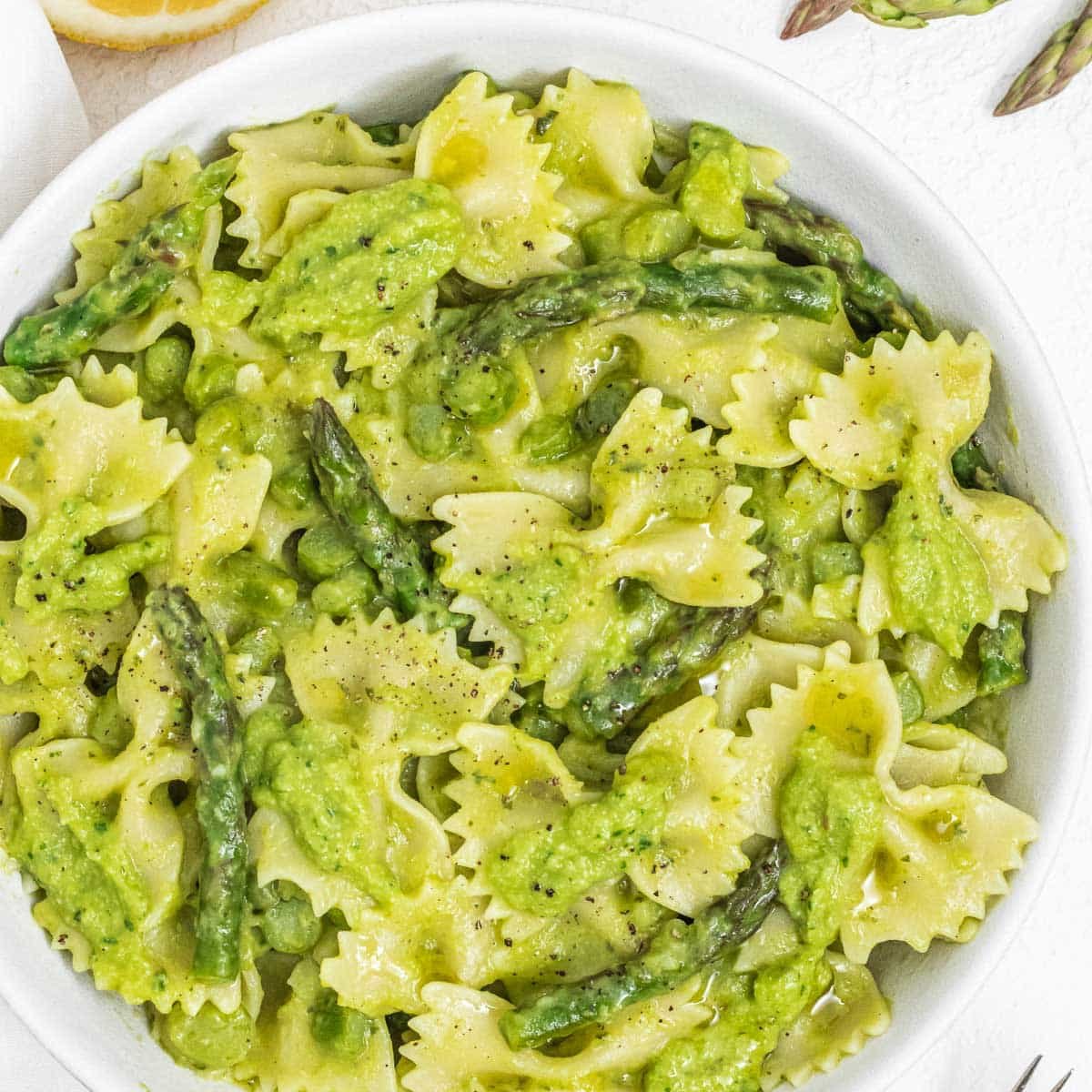 Asparagus pasta in a white bowl with asparagus tips