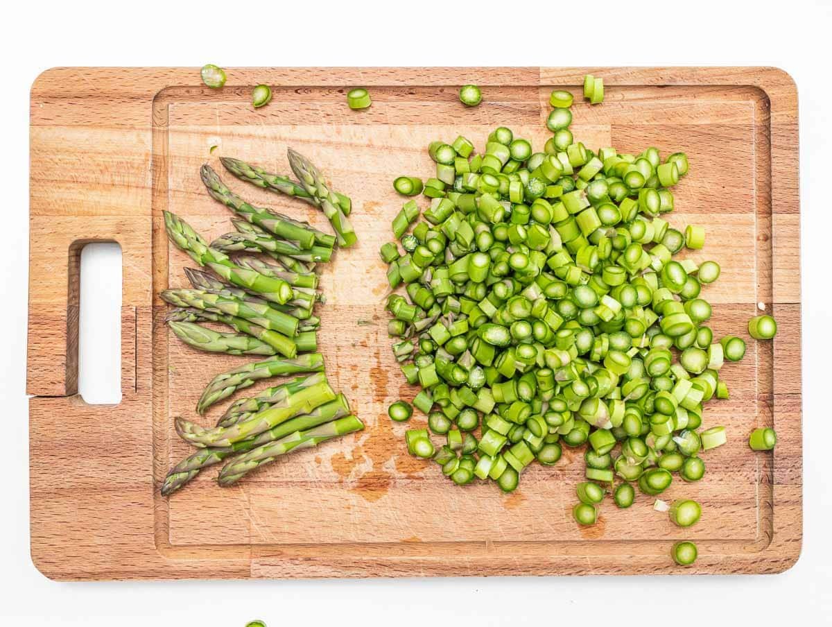 asparagus tips and small bits on a cutting board
