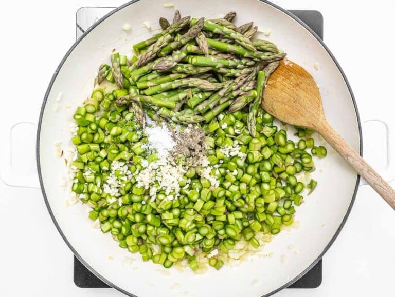 Asparagus bits and tips in a white skillet