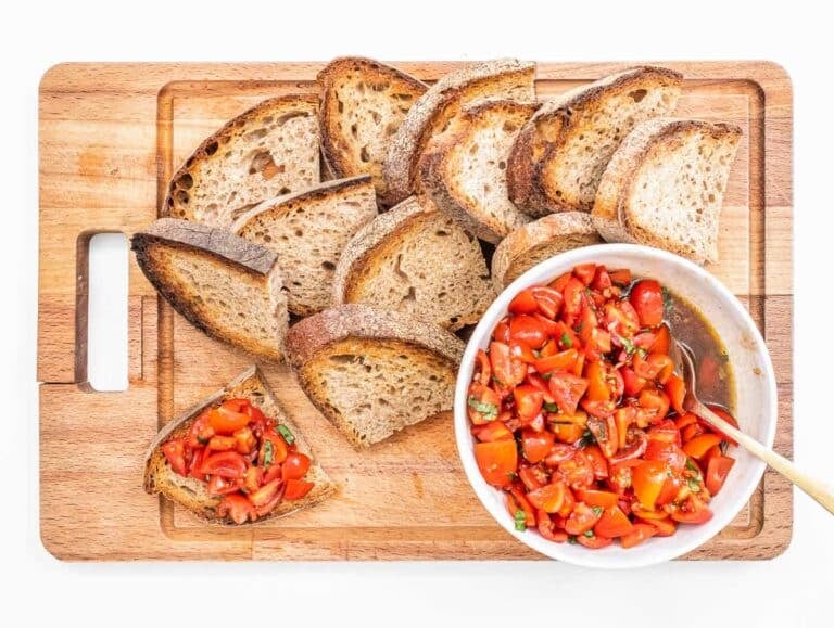 Bruschetta bread and tomato on a cutting board