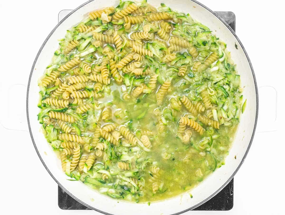 pasta and grated zucchini in a skillet