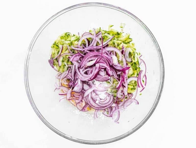 Zucchini and red onion in a glass bowl