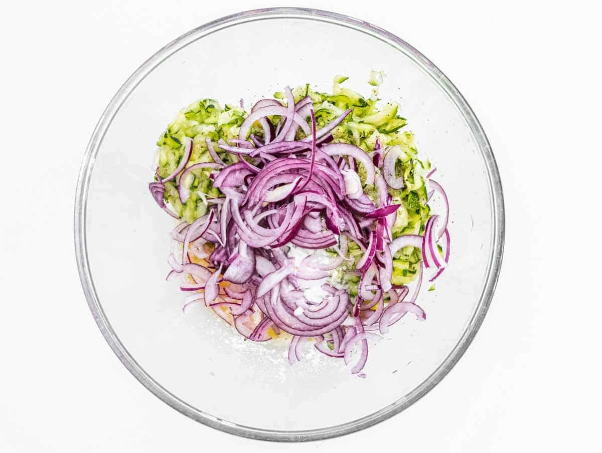 Zucchini and red onion in a glass bowl