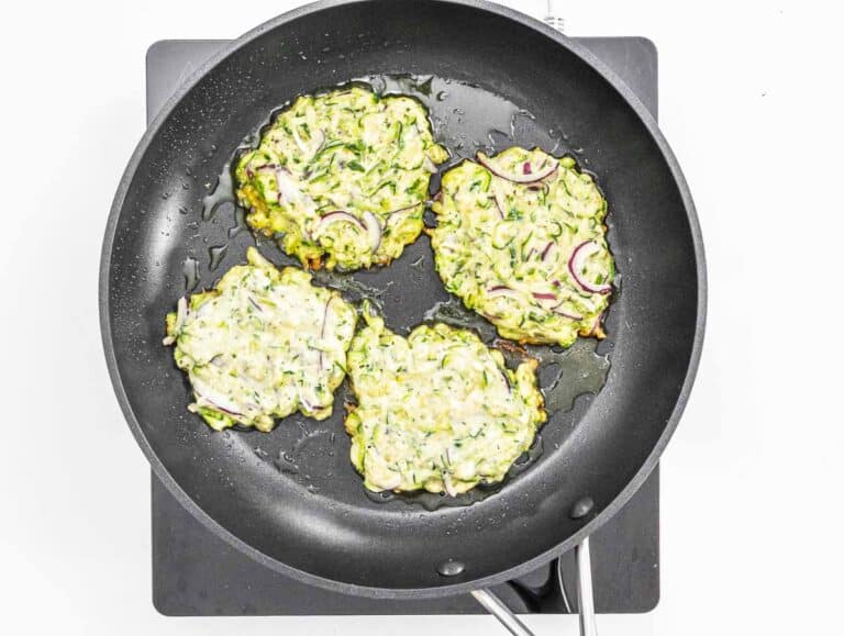 Zucchini fritters on a pan with oil