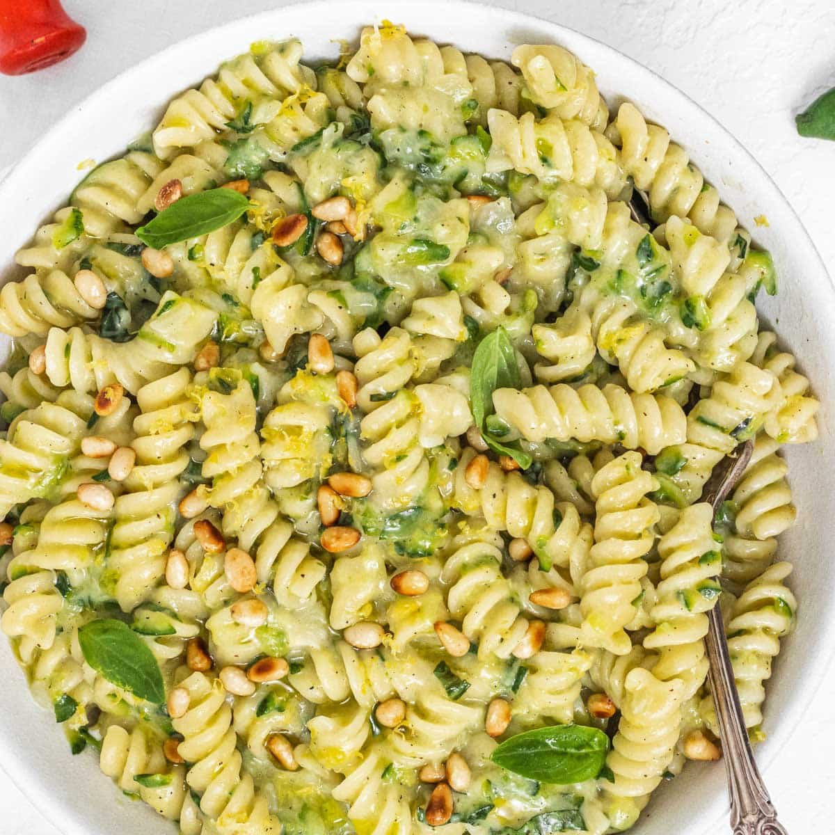 Zucchini pasta with pine nuts and fork