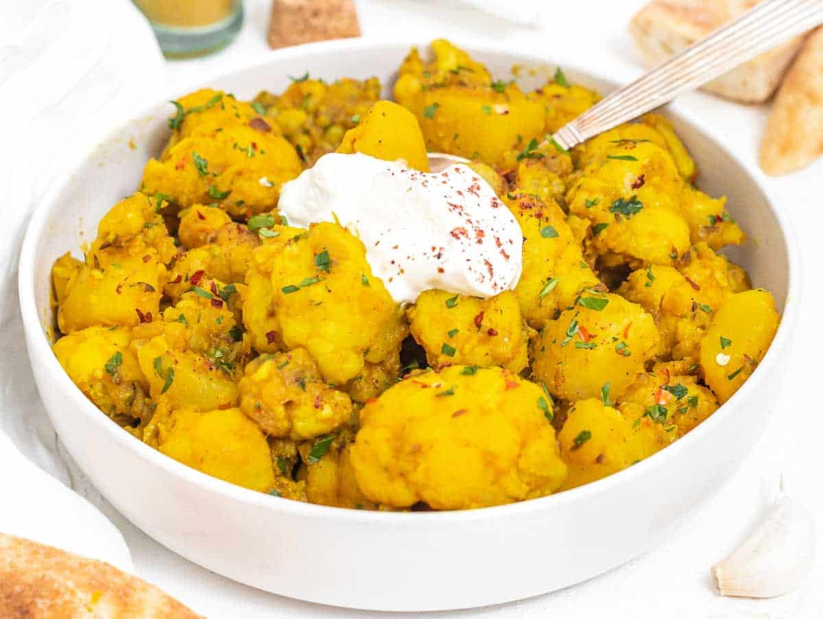 aloo gobi in a bowl with yogurt