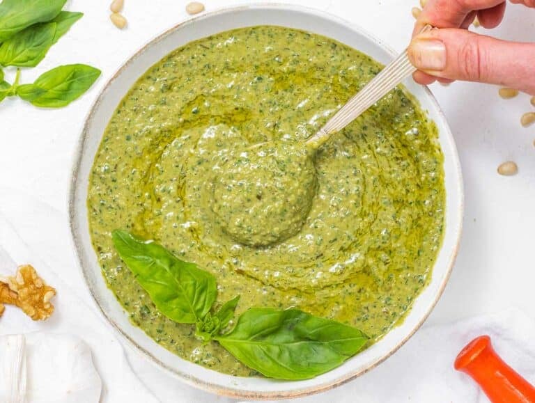 Basil Pesto with hands and basil leaves