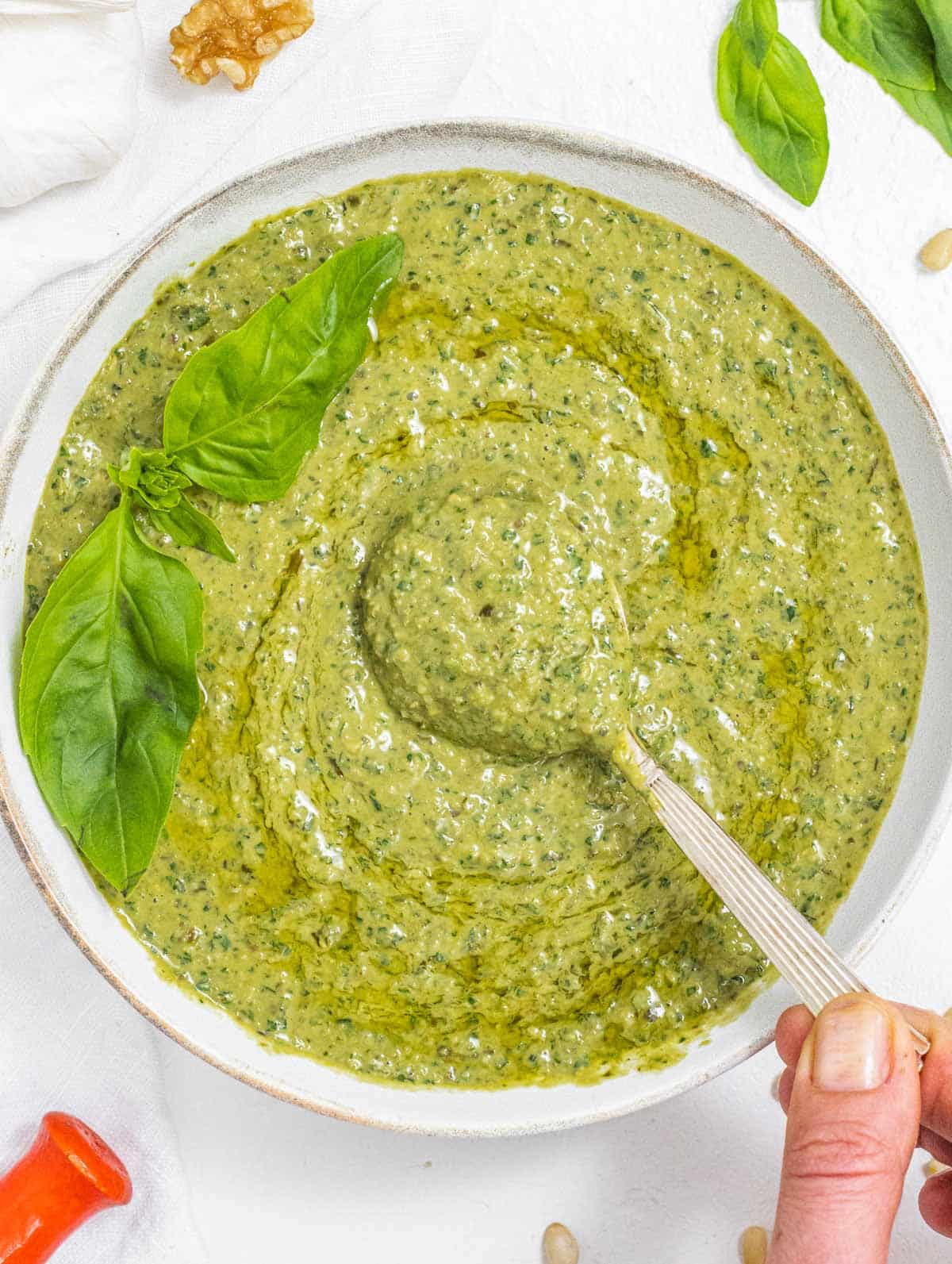 Basil Pesto with hand and spoon