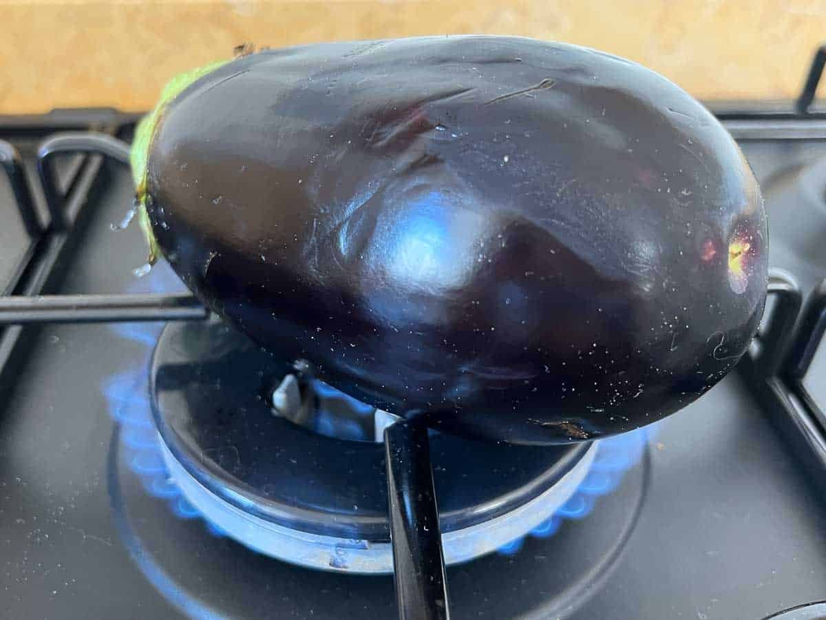 Charred eggplant on fire