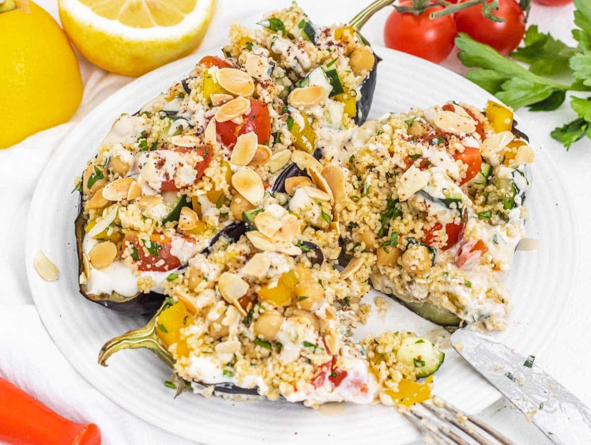 Couscous salad on a tender roasted eggplant with fork and knife