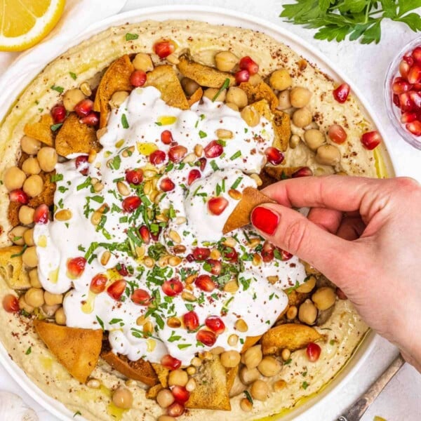 Fatteh hummus with hand and red nails