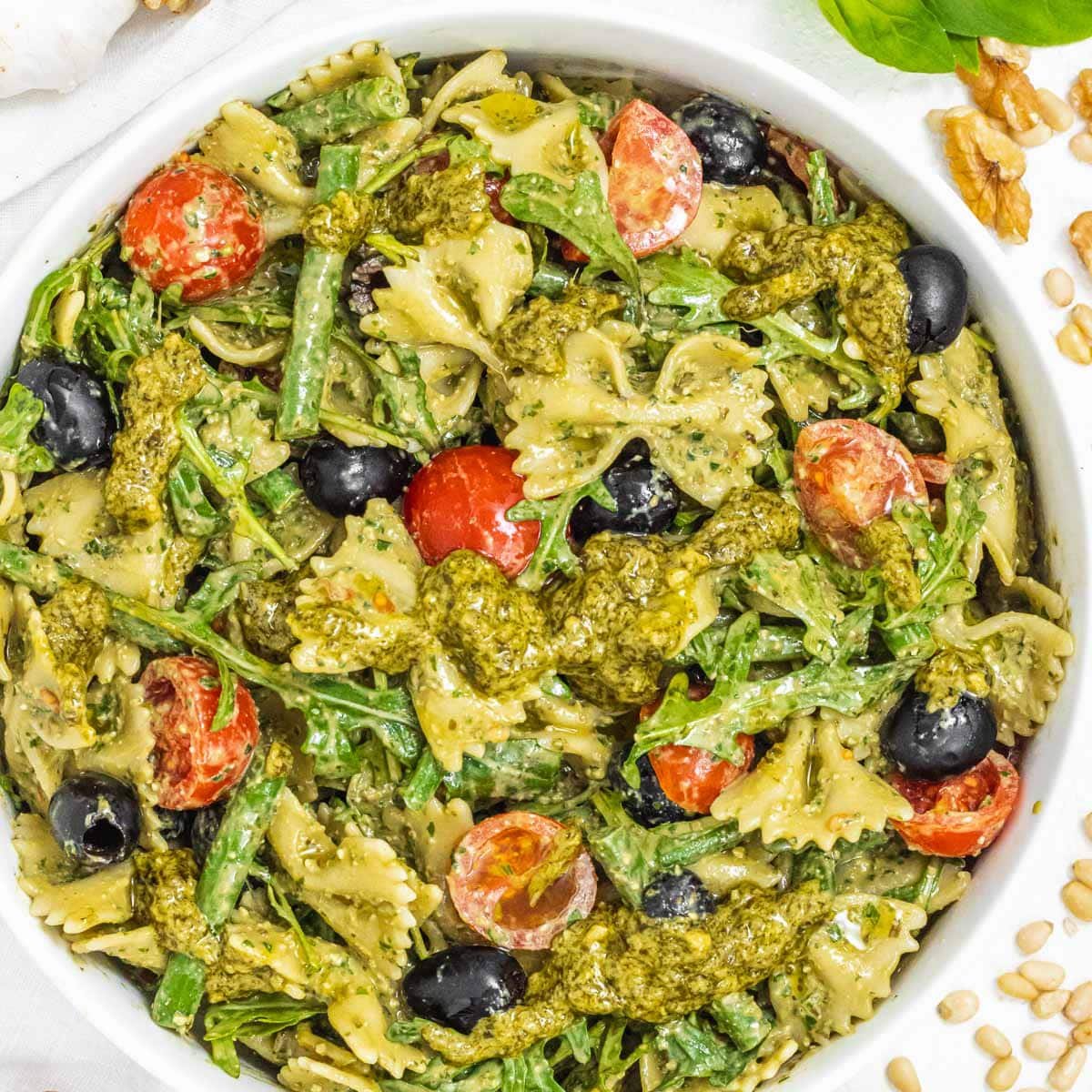 Pesto pasta salad in a bowl with tomatoes