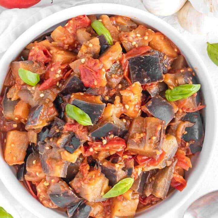 Sauteed eggplant in a bowl with basil