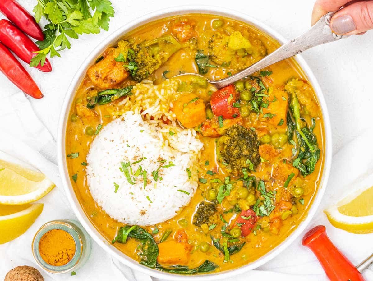Vegetable curry with spoon and hand