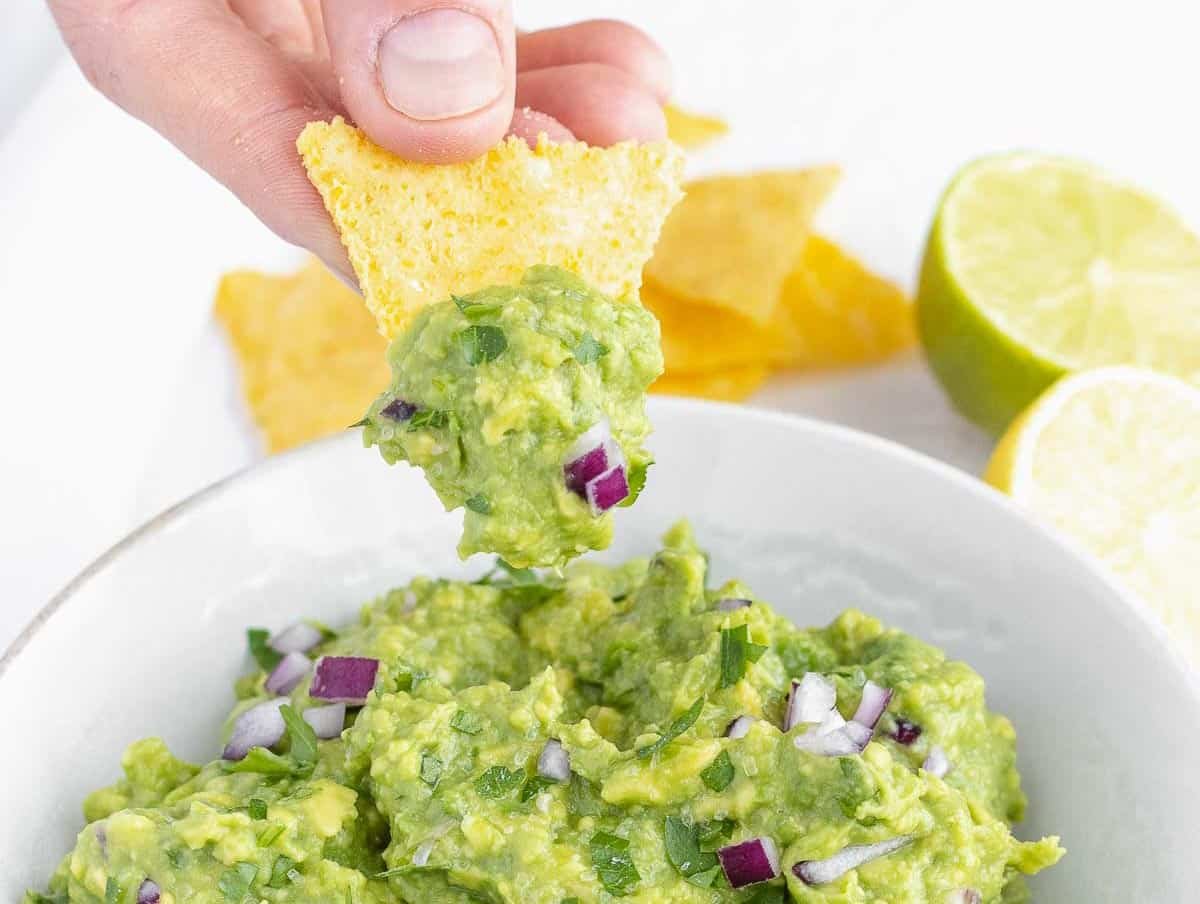 Guacamole with hand and nachos