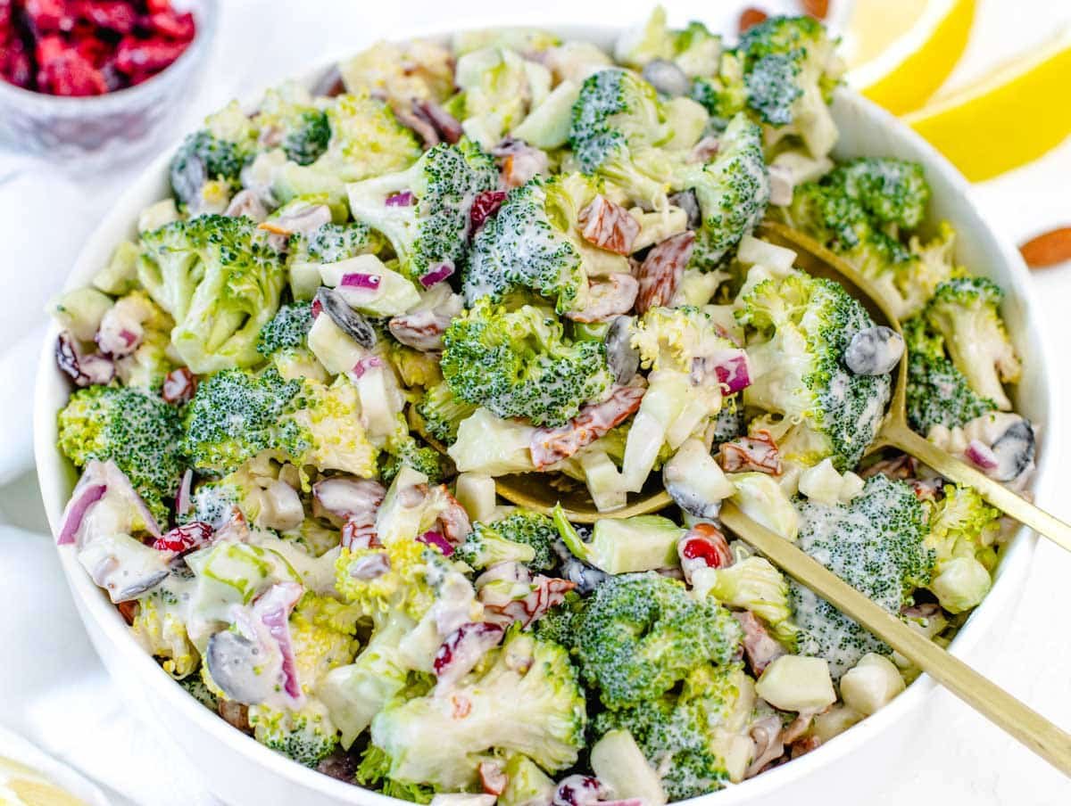 Broccoli Salad in a white bowl with lemon on the side