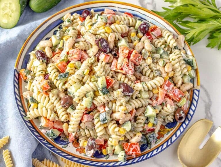 Creamy pasta salad on a blue plate with parsley on the side