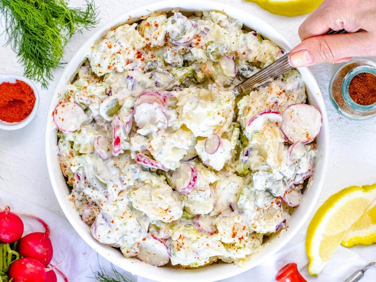 Dill Potato Salad with hand and spoon