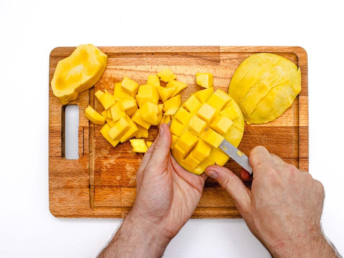 Removing diced mango from its peel