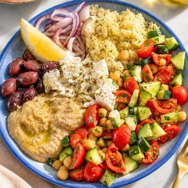 Mediterranean Bowl with hummus, marinated chickpeas, feta, olives, and fresh lemon wedges.