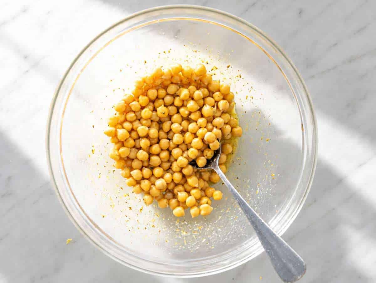 Step 1 Mixing olive oil, lemon juice, mustard, honey, garlic, oregano, and chickpeas.
