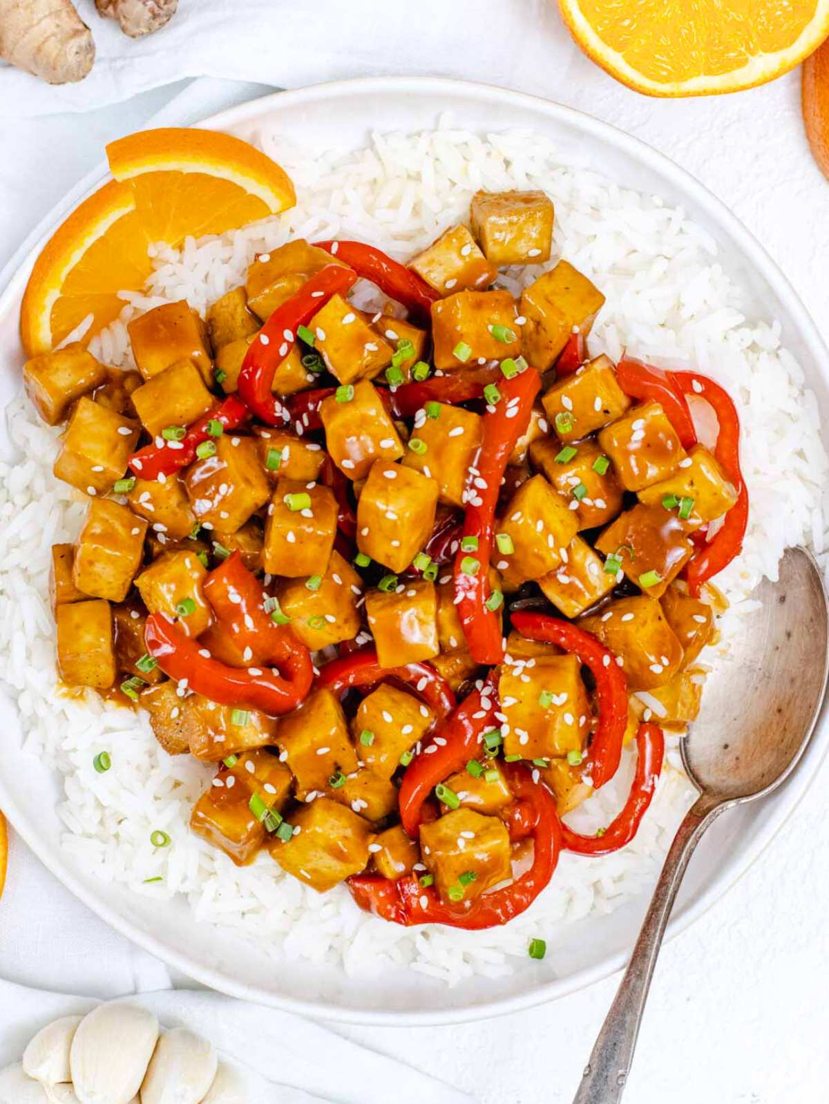 high protein orange tofu with a silver spoon.