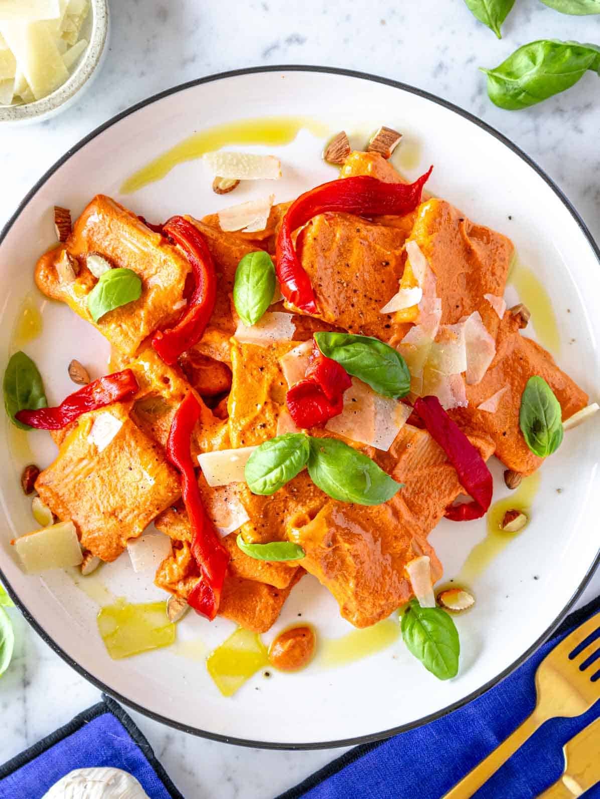 roasted pepper pasta with fresh basil on a white plate