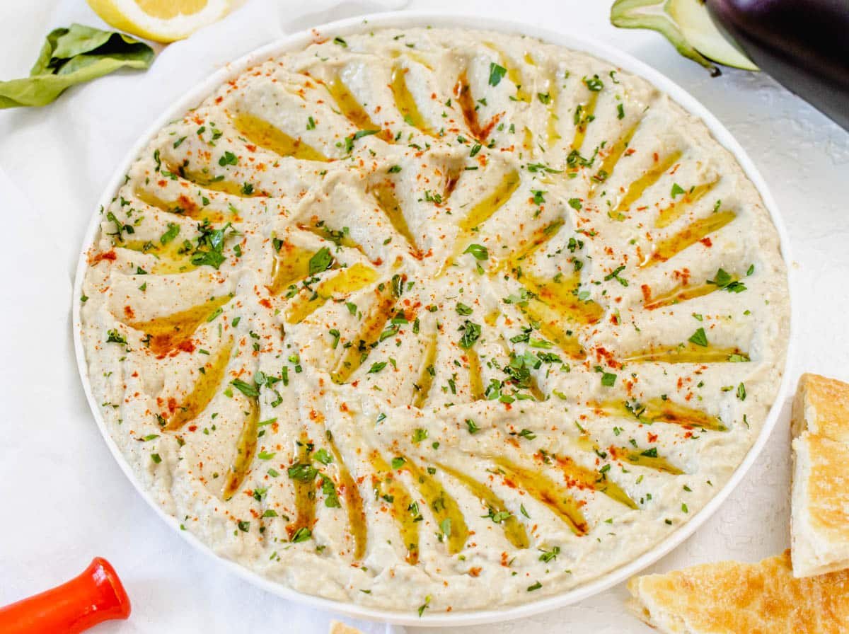 baba ganoush spread out on a serving platter with olive oil and smoked paprika