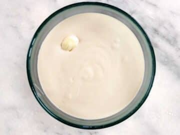 Tahini sauce with a whole clove of garlic