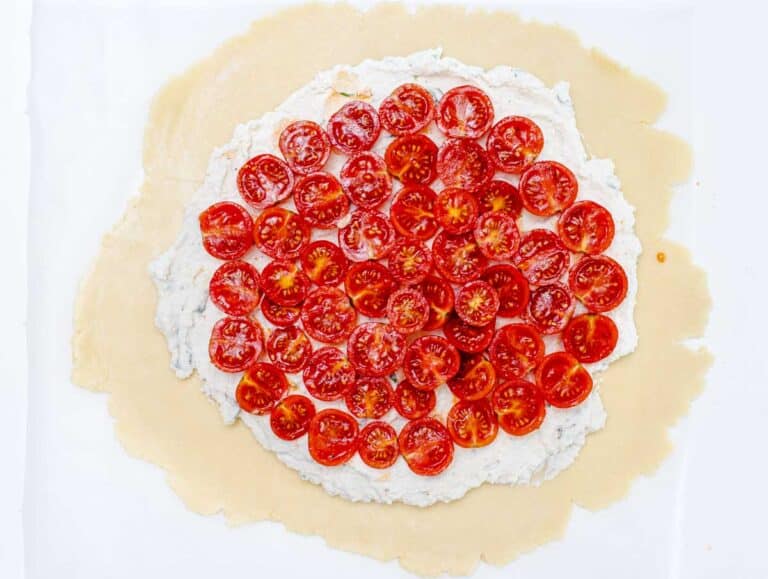 halved cherry tomatoes on pie crust